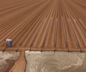 Aerial view of a man working in an irrigation field with a Discovery Channel bug in the bottom right corner